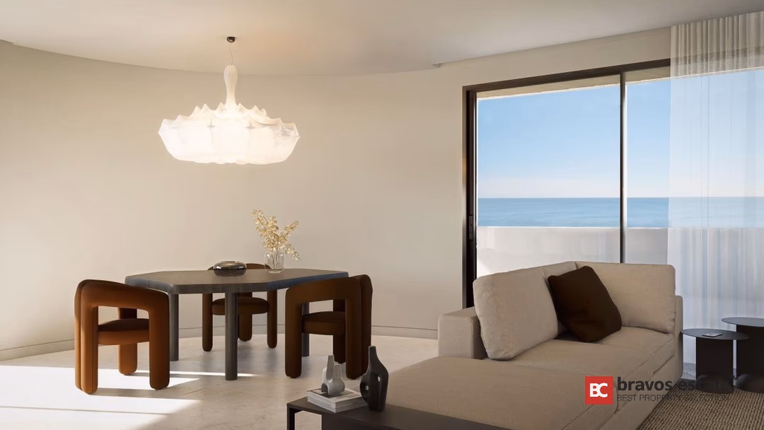 Гостиная-столовая в Los Balcones de Calpe: кремовый диван, обеденный стол и панорамный вид на море через большие окна