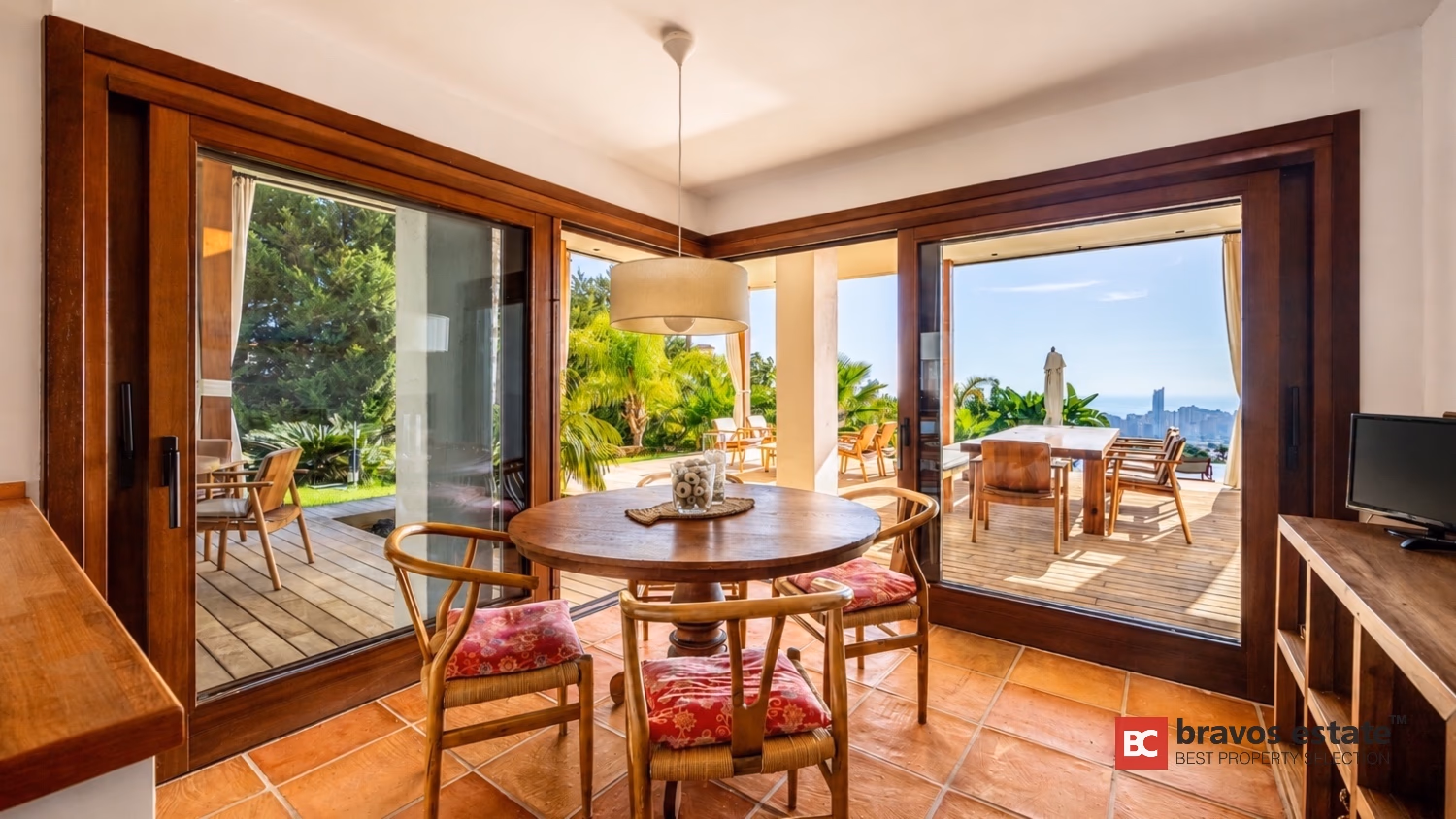 Столовая Villa Ibiza с деревянными раздвижными дверями, открывающимися на террасу и море