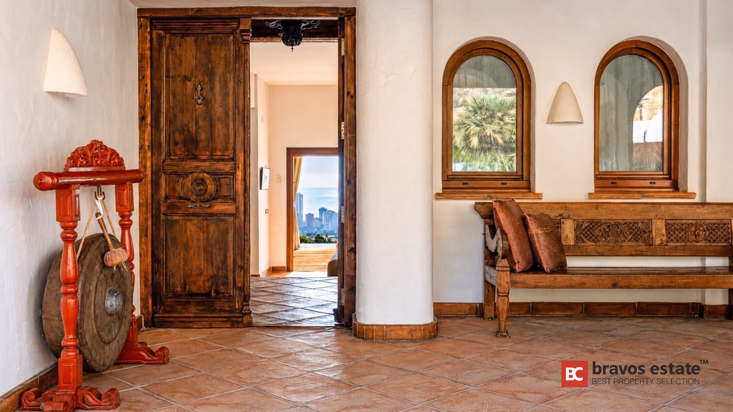 Входной холл Villa Ibiza с резной антикварной деревянной дверью и арочными нишами окон