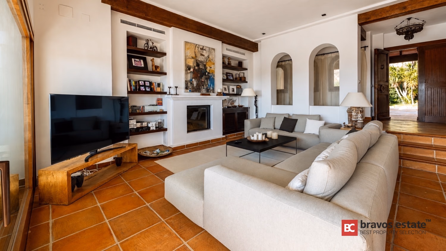 Гостиная Villa Ibiza с телевизором, камином, встроенными полками и терракотовым полом