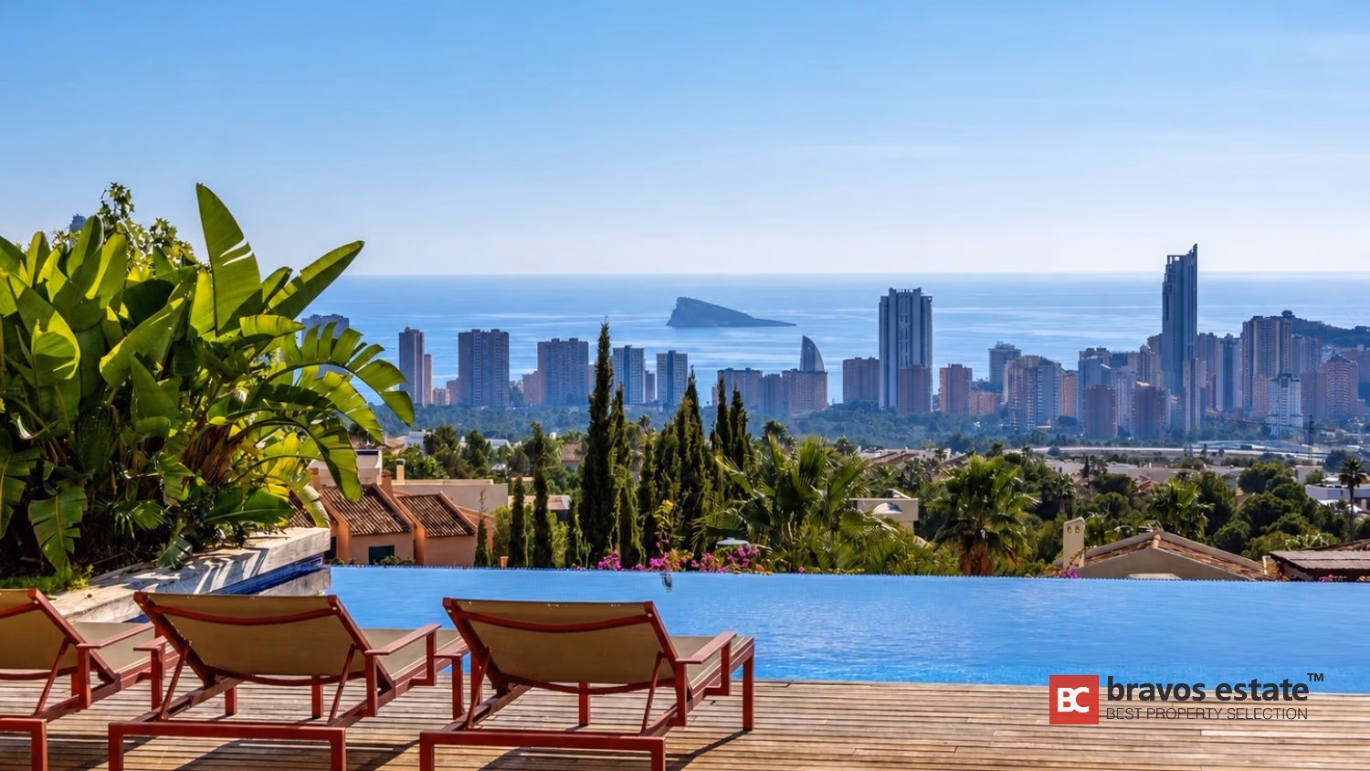 Бассейн-инфинити с шезлонгами и пальмами с видом на горизонт Benidorm в Villa Ibiza