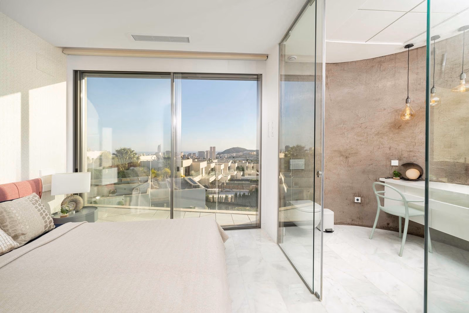 Bedroom with glass shower enclosure and travertine accent wall