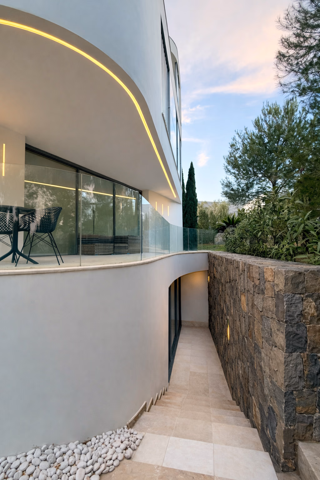 Twilight view from terrace with stone retaining wall and glass guard