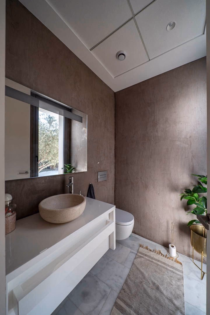 Guest powder room with stone basin and microcement walls
