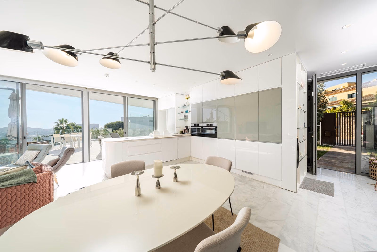 Open kitchen-dining with sculptural pendant lights and terrace access