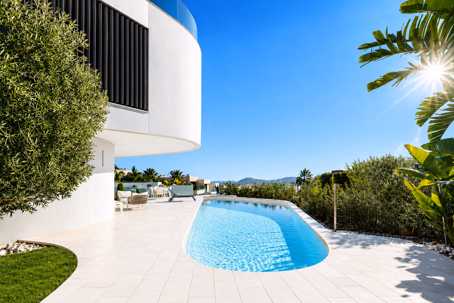 Sunlit pool terrace with curved white facade, olive tree and palm fronds