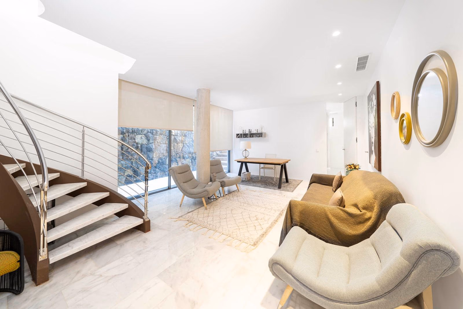 Basement lounge with spiral staircase and stone feature wall
