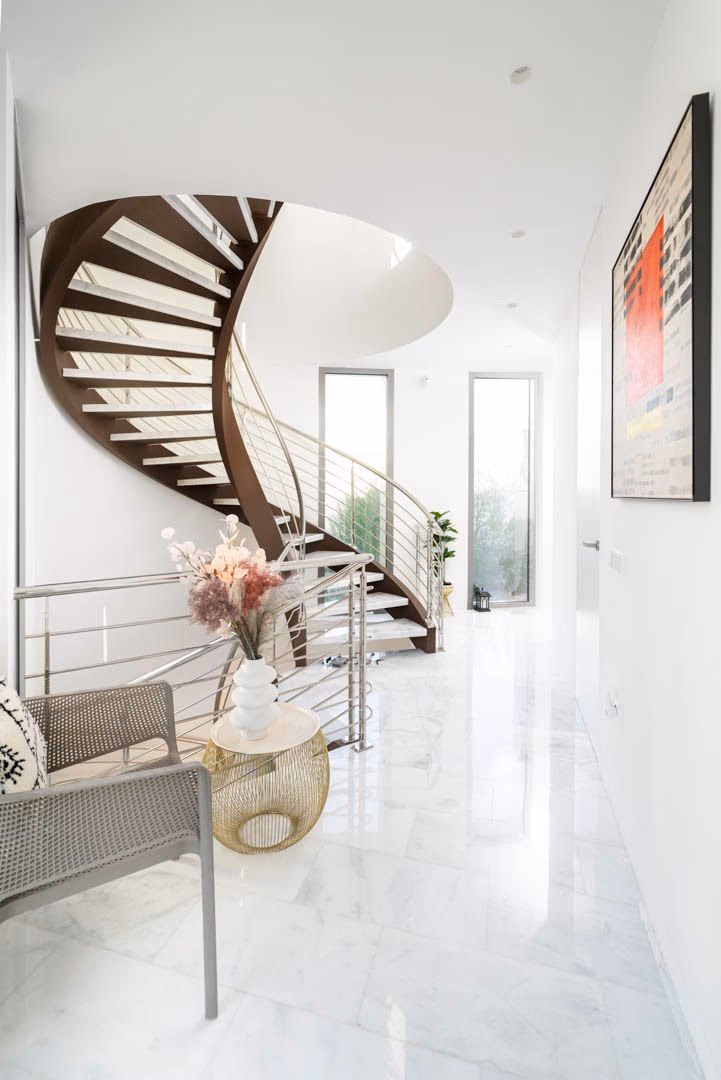 Sculptural spiral staircase rising through the entrance hall