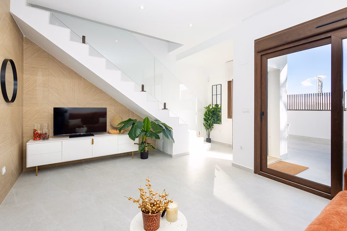 Стена с телевизором под лестницей и раздвижная дверь на террасу