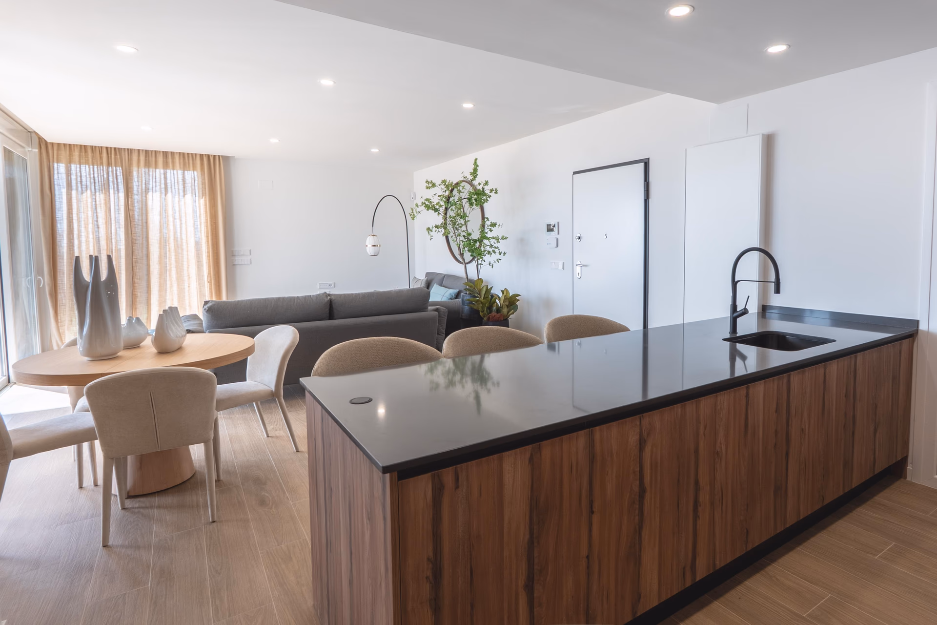 Kitchen island with dark worktop and wood-panelled units