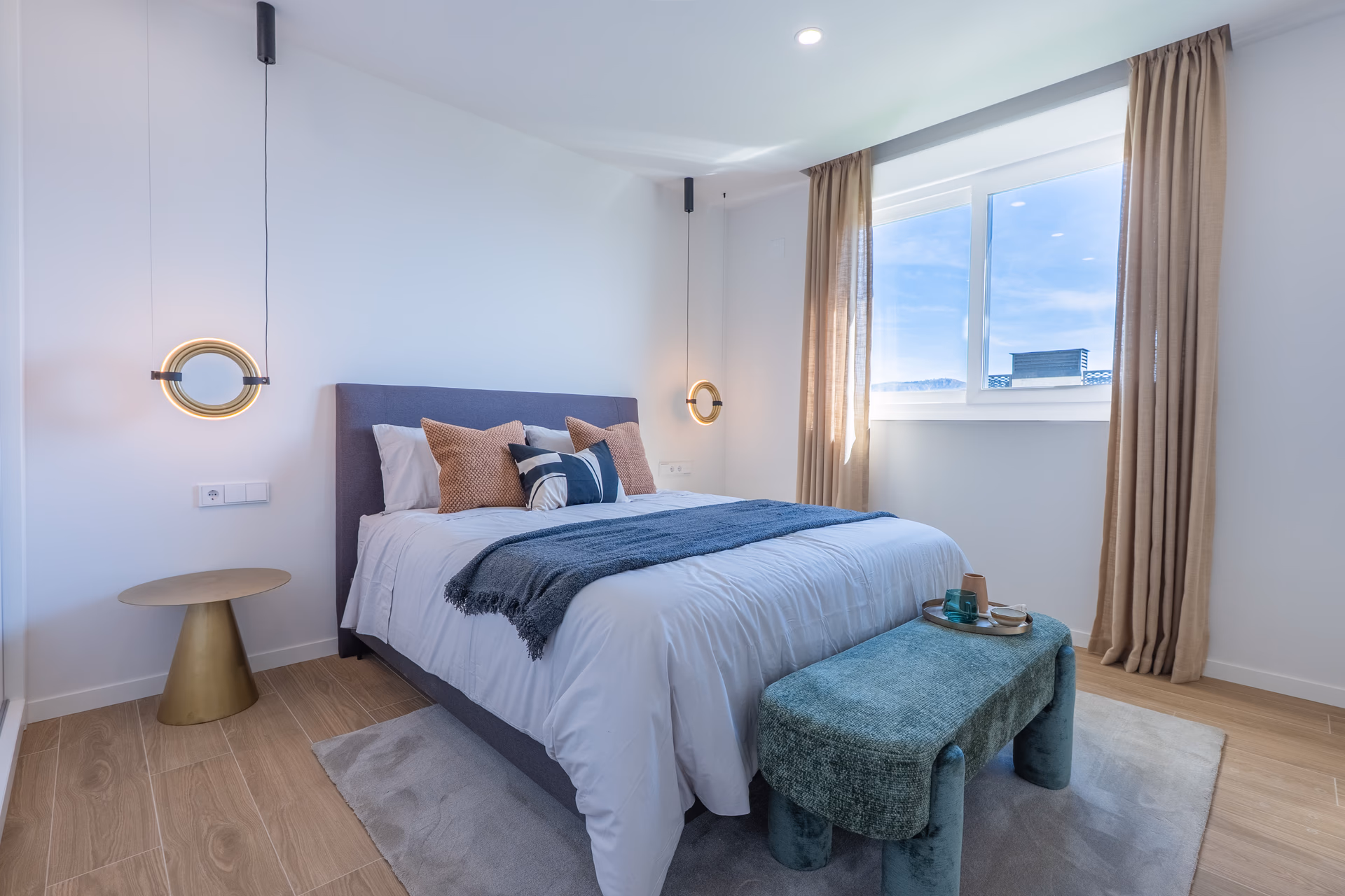 Bedroom with upholstered headboard, bench and pendant lights
