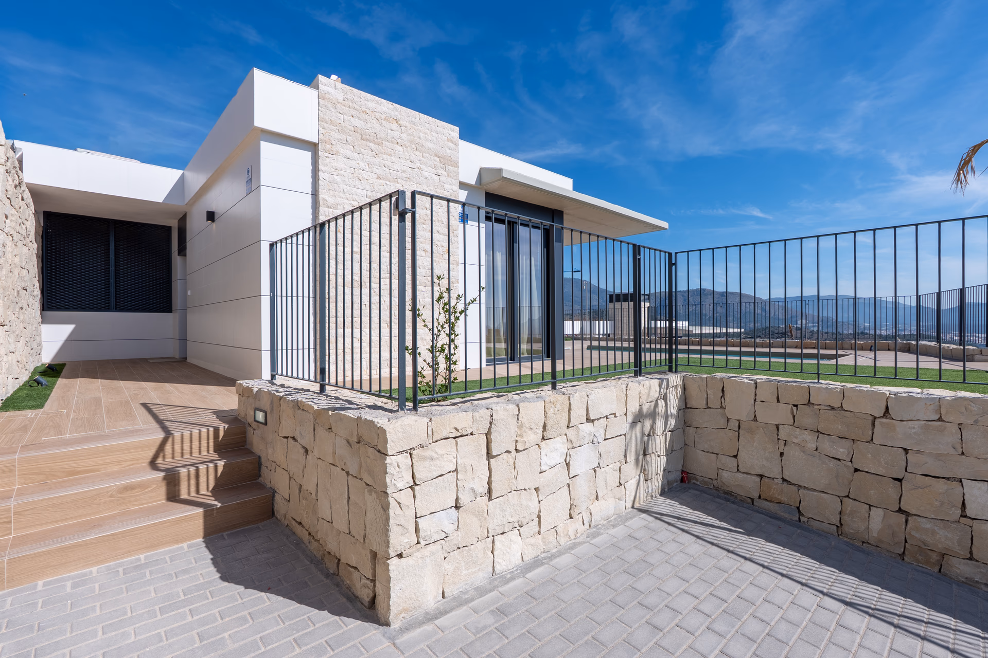 Entrance steps and stone wall of the show villa with the valley behind