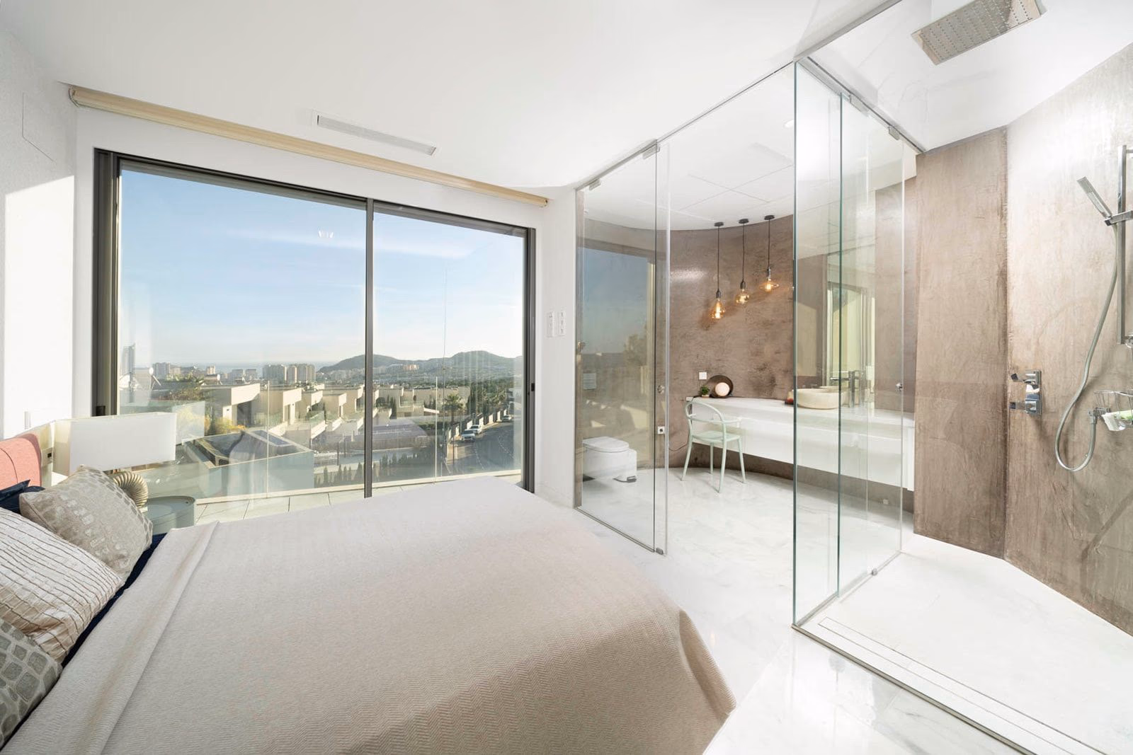Bedroom with glass-walled shower and microcement vanity