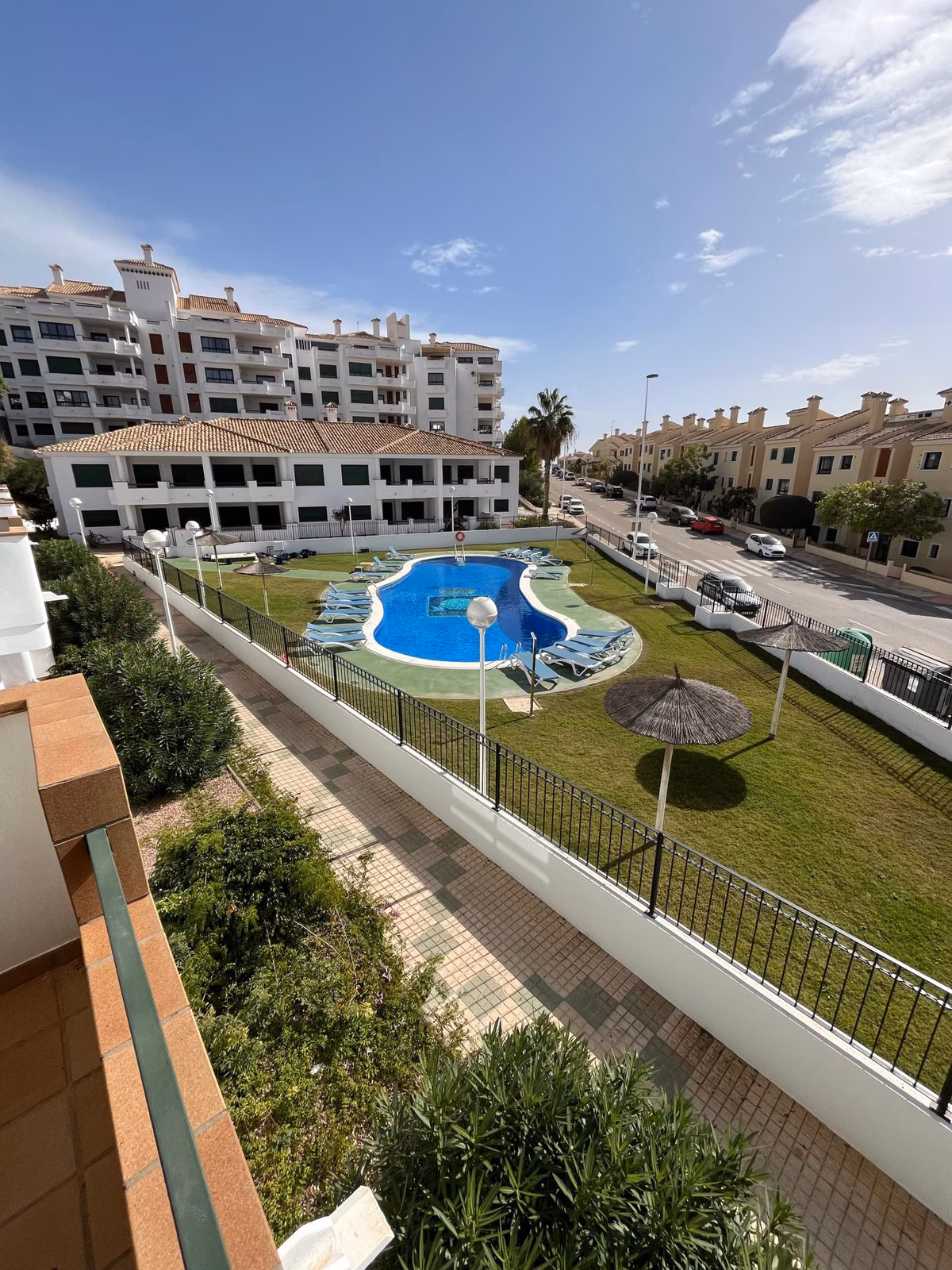 Вид с террасы на общий бассейн и сад Residencial Iron