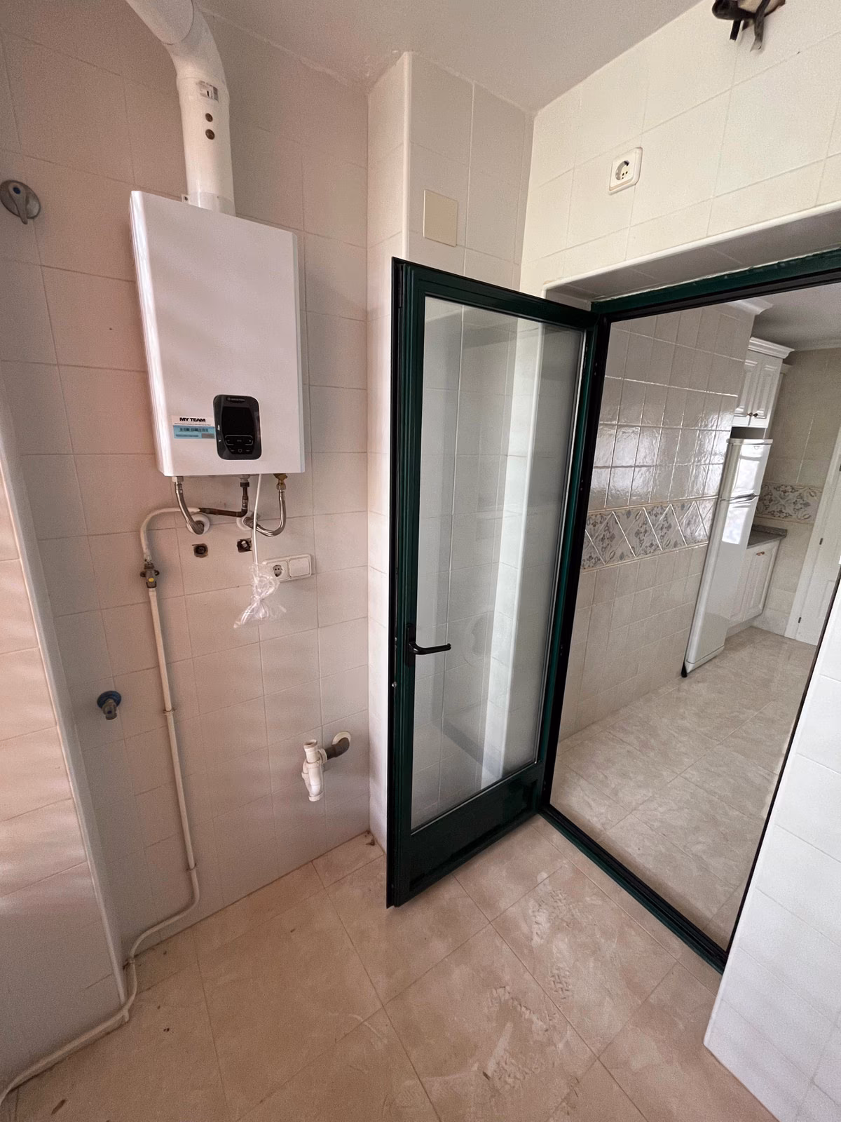 Подсобное помещение с котлом и стеклянной дверью в Residencial Iron