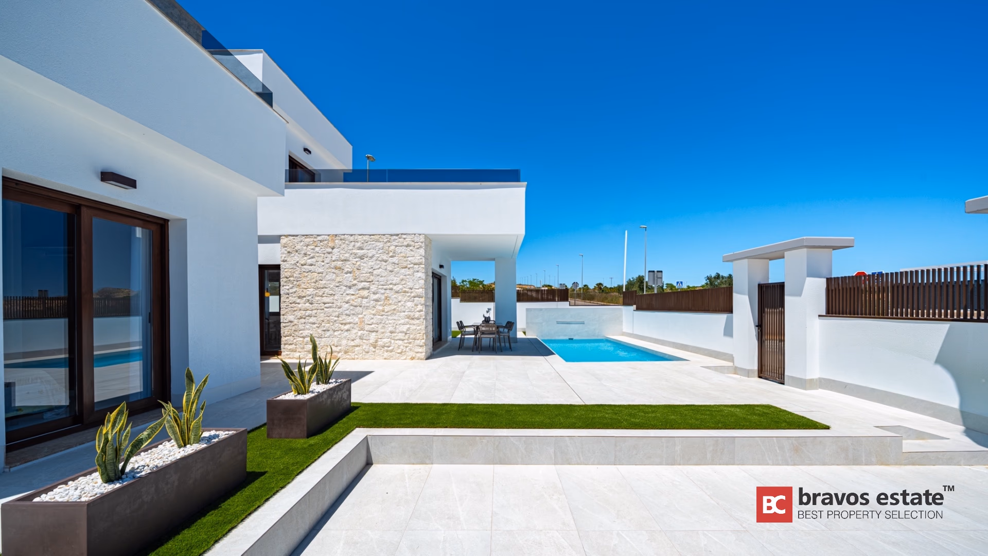 Боковая терраса с бассейном и газоном в Villa Valencia