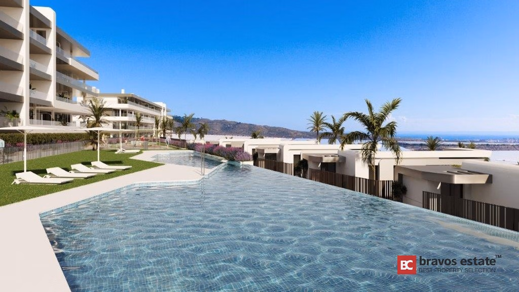 CGI-рендер общего инфинити-бассейна в Bonalba Green Villas: шезлонги, пальмы, белые крыши вилл и панорамный вид на побережье под ясным голубым небом.